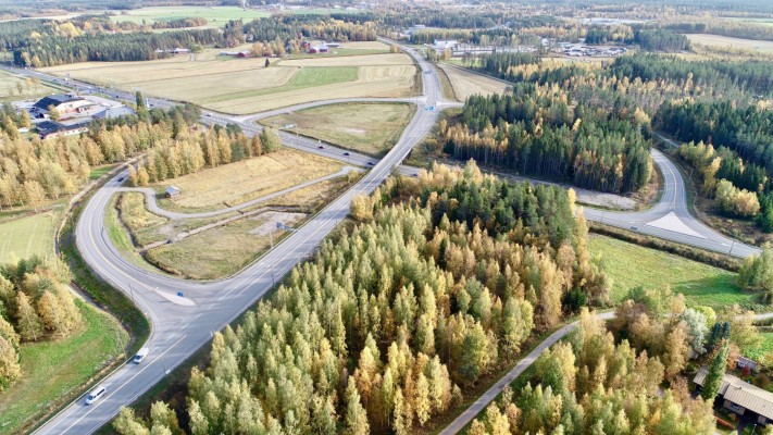 Flygbild över Edesevökorsningen där riksåttan korsar Kållbyvägen. Landsväg, fält och skog.