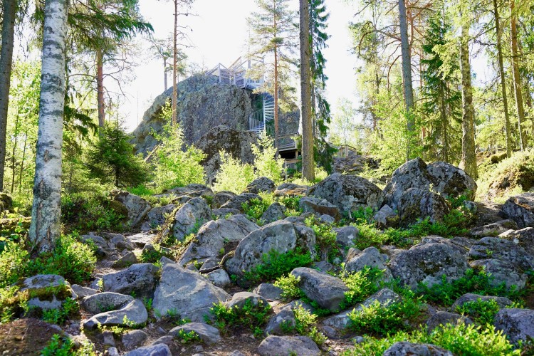 Stort flyttblock i skogen, omgiven av mycket stenar.