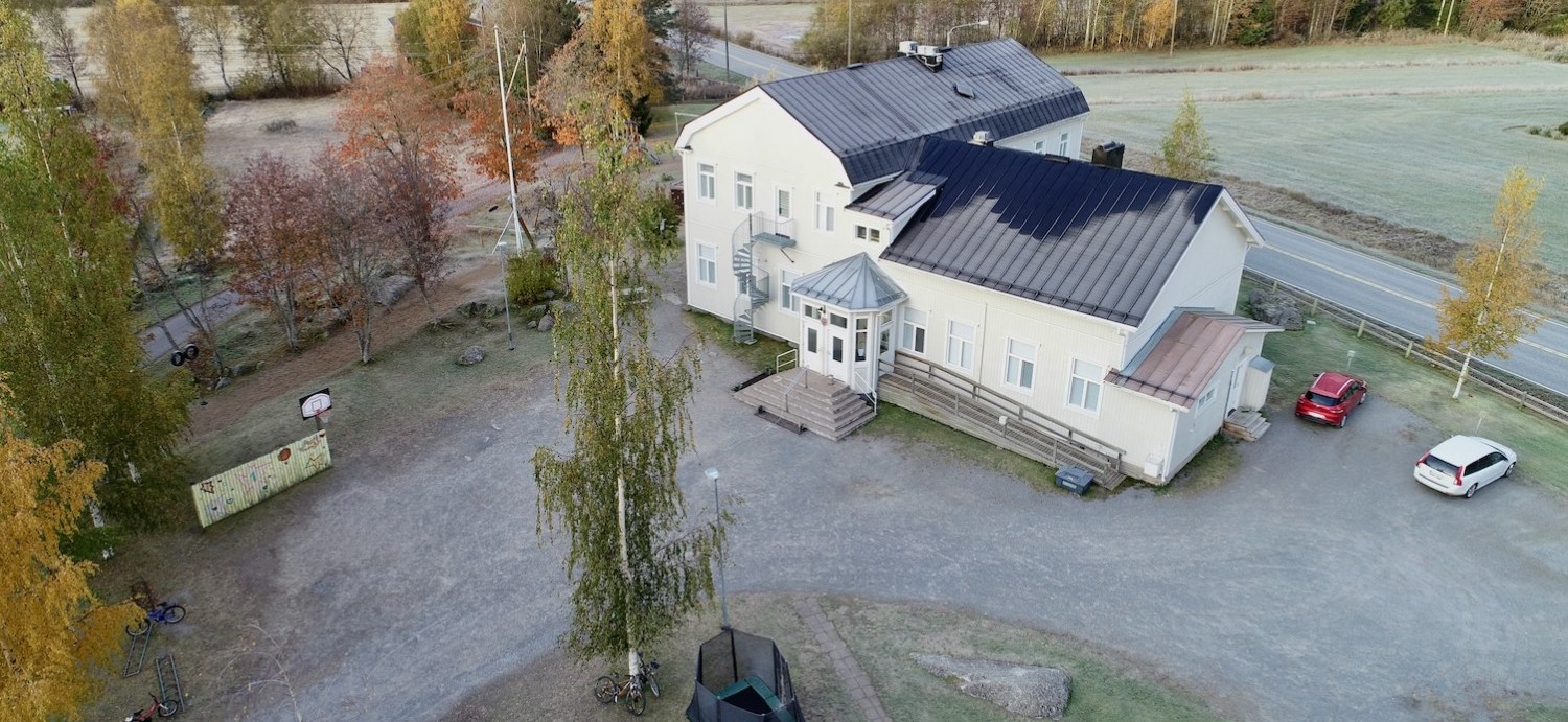 Flygbilder över Sundby skola, delar av skolgården syns. Det är barmark.