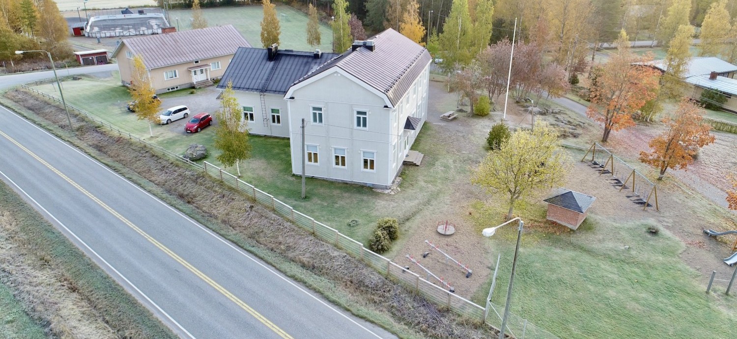 Flygbilder över Sundby skola, delar av skolgården syns. Det är barmark.