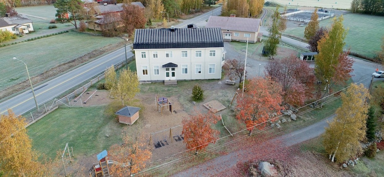 Flygbilder över Sundby skola, delar av skolgården syns. Det är barmark.