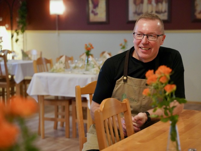 Yrittäjä Ulf Hagman istuu pöydän ääressä omassa ravintolassaan.