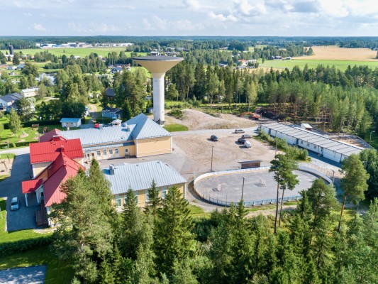 En bild över Kållby, där vattentornet, delas av skolan och förskolan syns.