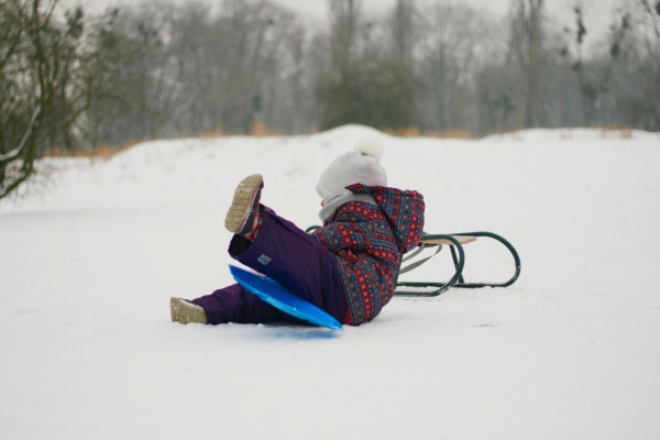 Ett barn åker på snö med ett "tefat".