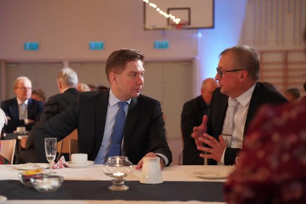 Minister Thomas Blomqvist samtalar med Greger Forsblom vid ett bord.