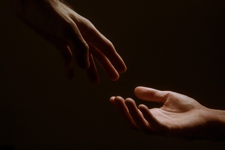 Två händer som sträcker sig mot varandra. 